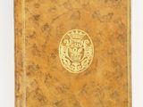 un vieux livre avec un emblème en or sur la couverture