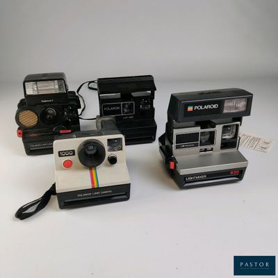 trois appareils photo Polaroid posés les uns sur les autres sur une table