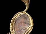 une image représentant un pendentif en or et en agate orné d'un serpent
