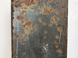 a rusted piece of metal hanging on the wall