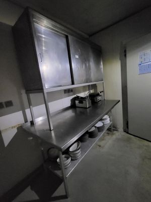 dimly lit commercial kitchen with stainless steel counter tops and stainless steel cabinets