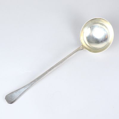 a silver spoon with a spoon handle on a white surface