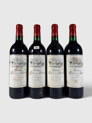 trois bouteilles de vin rouge sont alignées sur une surface blanche