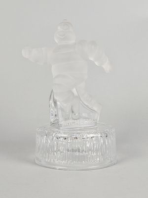 figurine en verre transparent représentant un snowboardeur, posée sur un socle transparent