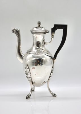 an antique silver tea pot with a black handle on a white surface