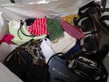 a bag of clothes and bags in the back of a car