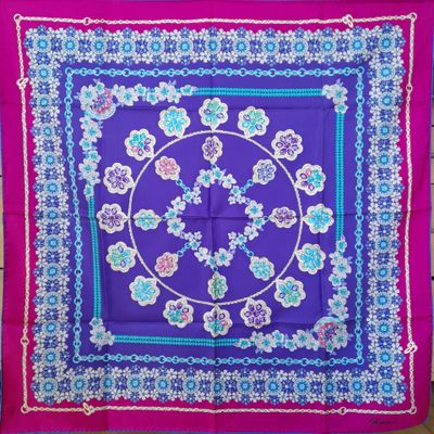 a close up of a purple and blue square with flowers on it