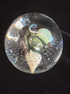 une boule de verre contenant un anneau, posée sur une surface noire