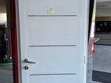 a white door with a red handle in a room