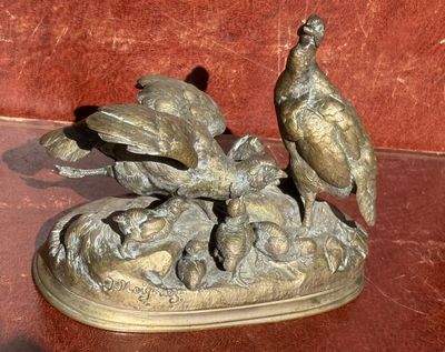 une statue en bronze représentant un faisan posée sur une table