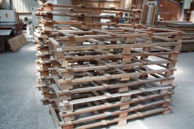 a large pile of wood pallets in a warehouse