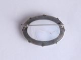 a picture of a silver broochle on a white surface
