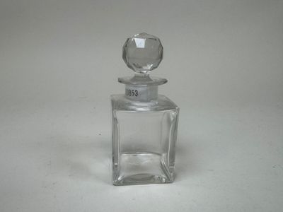 une petite bouteille en verre munie d'un bouchon en verre