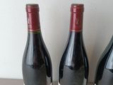three bottles of wine sitting on a table next to each other