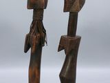une paire de sculptures en bois représentant un homme et une femme tenant des parapluies