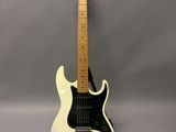 une guitare électrique blanche posée sur une surface grise