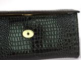 black alligator skin purse with a gold clasp on a white background
