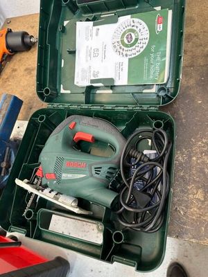 une boîte verte posée par terre, contenant des outils