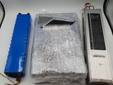 two batteries, a battery case, and a laptop on a table