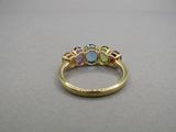 gros plan d'une bague en or avec trois pierres de couleurs différentes