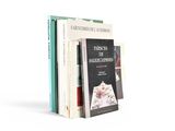 three books are stacked on top of each other on a white surface