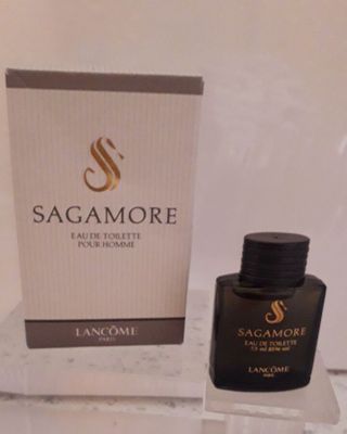 un flacon de parfum posé à côté d'une boîte sur une table