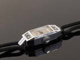 a close up of a wrist watch on a black string