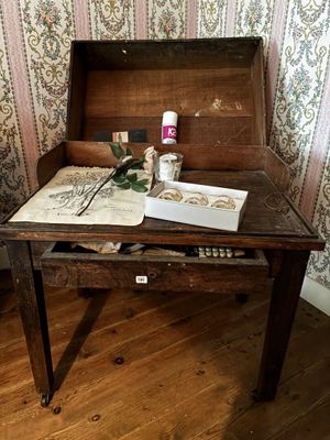 une table en bois sur laquelle se trouvent un livre et une bouteille