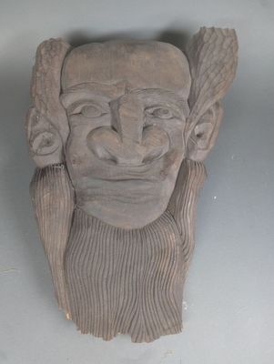 une sculpture en argile représentant un homme barbu coiffé d'un chapeau
