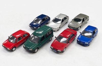 plusieurs petites voitures sont alignées sur une surface blanche