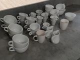 many cups and saucers sitting on the counter