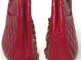 pair of red leather handbags with gold chain handles on a white background