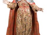 la statue d'une femme vêtue d'une robe dorée tend les mains