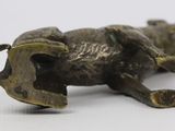 a bronze figurine of a bull on a white surface