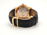 an image of a wrist watch with a gold case and black leather strap