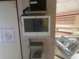 une télévision et un ordinateur portable posés sur une étagère dans une pièce