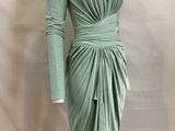 the mannequin is wearing a green dress on a white mannequin