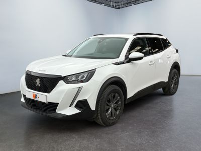 Le SUV blanc est garé dans une grande pièce au sol noir.