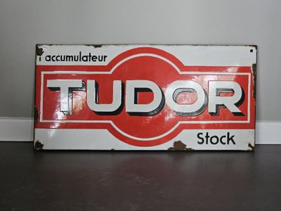 une enseigne rouge et blanche sur laquelle est inscrit « Tudor Stock »