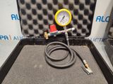 a black case with a yellow gauge and a hose in it
