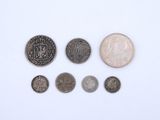 an assortment of coins and a coin on a white surface