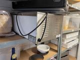 a microwave sitting on top of a shelf in a kitchen