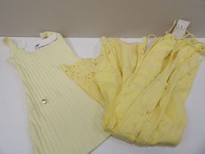 two yellow sweaters and a yellow dress on a white table