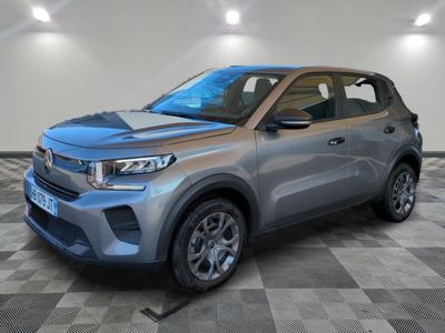 Une Kia Korox grise de 2020 est garée dans une pièce au sol carrelé.