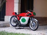 une moto rouge et verte garée devant un immeuble