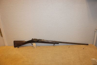 un vieux fusil posé sur une table près d'un mur