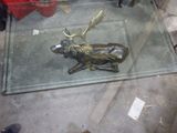 une table en verre sur laquelle se trouve un cerf en bronze