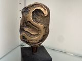a sculpture of a face on a black block