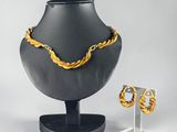 a necklace and earring set on display on a stand