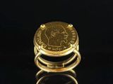 a gold ring with a coin on top of it